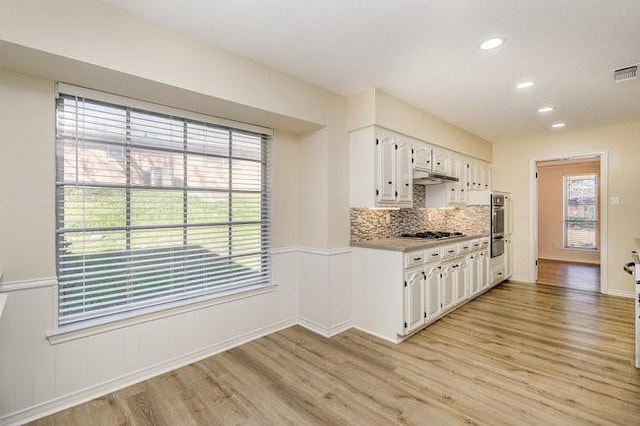 kitchen with stainless steel gas stovetop, a wealth of natural light, and white cabinets