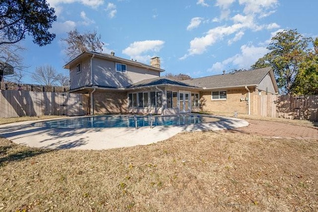 back of house with a yard, a fenced in pool, and a patio