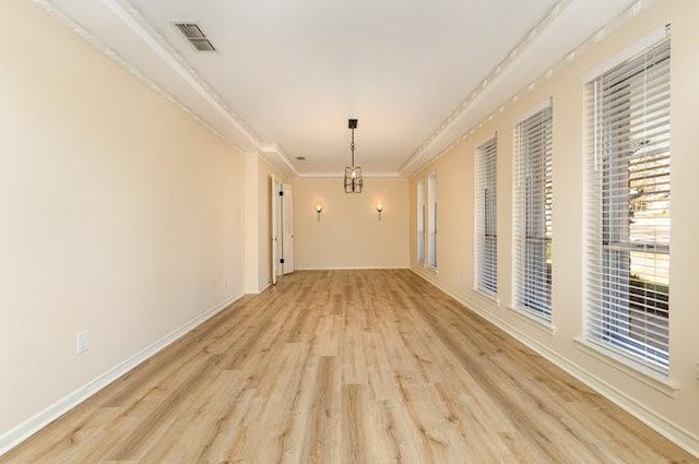 empty room with light hardwood / wood-style flooring and ornamental molding