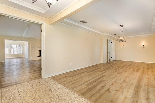 spare room with beam ceiling, crown molding, light hardwood / wood-style floors, and a chandelier