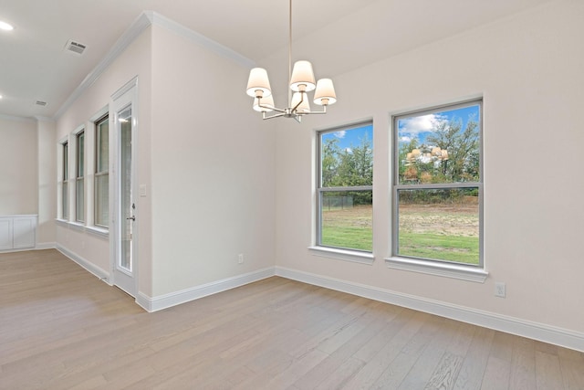 unfurnished dining area featuring a notable chandelier, ornamental molding, and light wood-type flooring