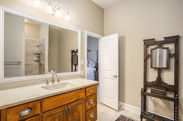 bathroom featuring tile patterned flooring, vanity, and a tile shower