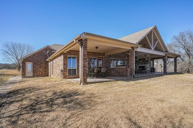 rear view of house featuring a yard and a patio area