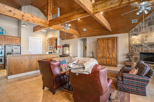 living room featuring wood ceiling, ceiling fan, a stone fireplace, and high vaulted ceiling