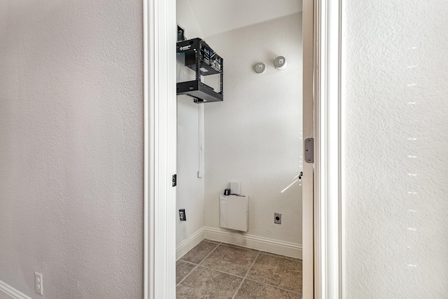 interior space featuring hookup for an electric dryer and tile patterned flooring