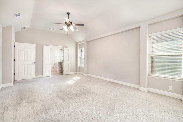 unfurnished bedroom with ceiling fan, connected bathroom, carpet flooring, and vaulted ceiling