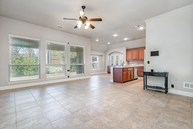 kitchen with sink, ceiling fan, backsplash, a center island, and stainless steel dishwasher