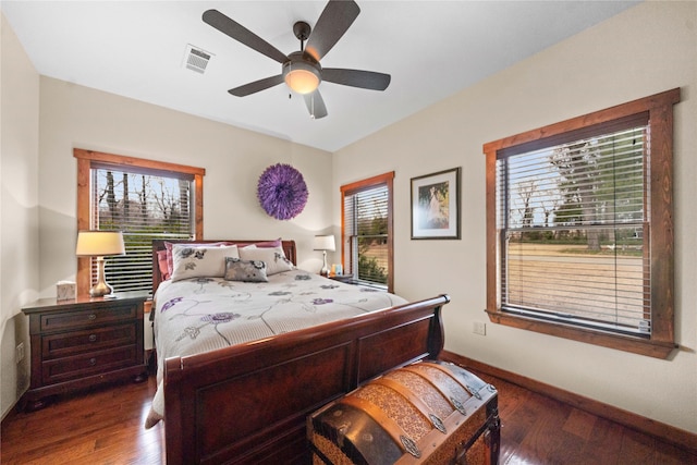 bedroom with ceiling fan, dark hardwood / wood-style flooring, and multiple windows