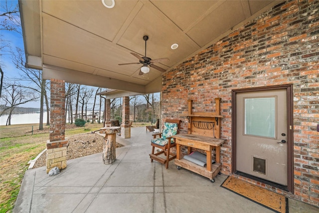 view of patio / terrace featuring a water view and ceiling fan