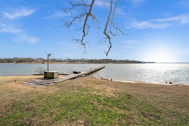 dock area with a lawn and a water view