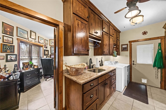 kitchen featuring sink, light stone counters, independent washer and dryer, and light tile patterned floors