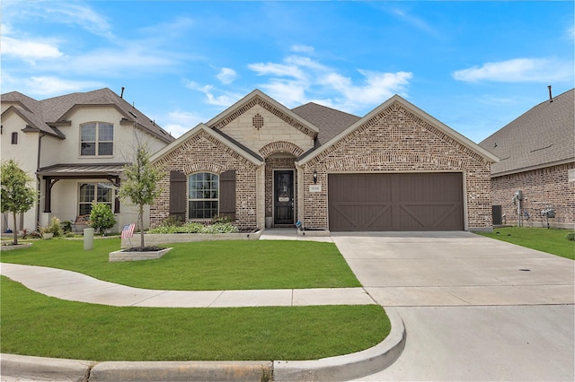 french country style house with a garage and a front lawn