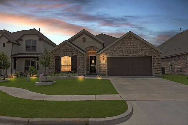 french provincial home with a garage and a lawn