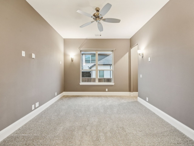 carpeted spare room featuring ceiling fan