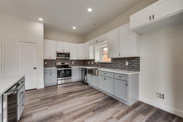 kitchen featuring tasteful backsplash, stainless steel appliances, beverage cooler, and white cabinets