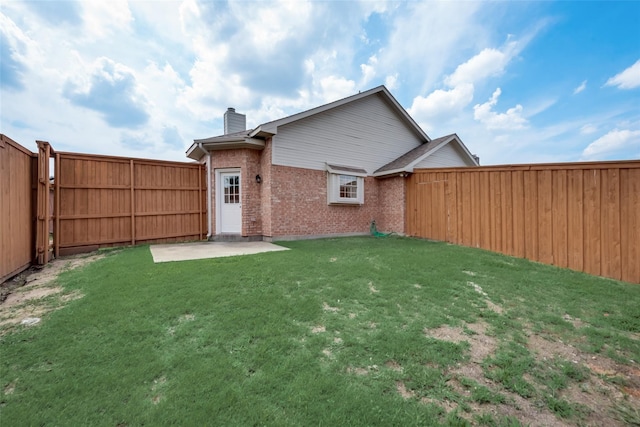 back of house featuring a patio area and a lawn