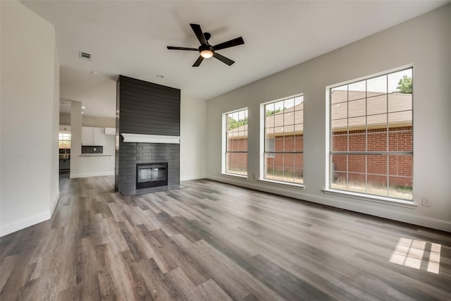 unfurnished living room with ceiling fan, a fireplace, and hardwood / wood-style floors