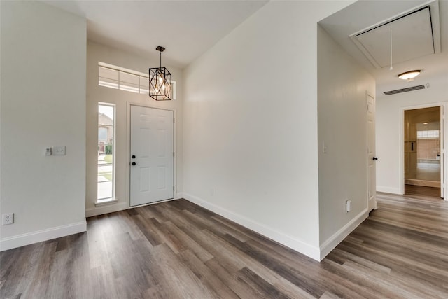 foyer with a notable chandelier and dark wood-type flooring