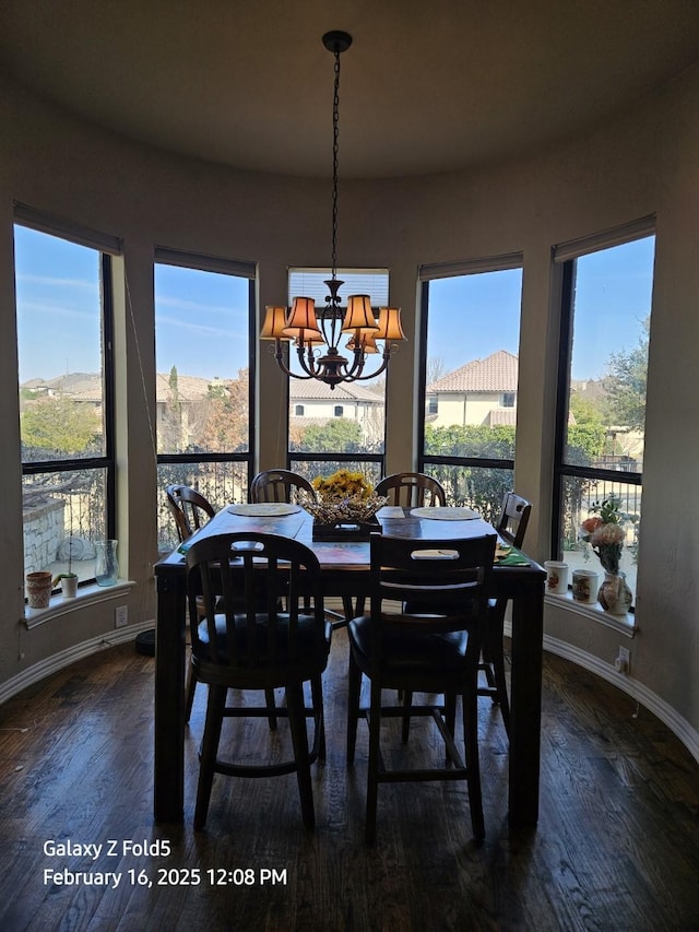 dining space featuring dark hardwood / wood-style flooring and a chandelier