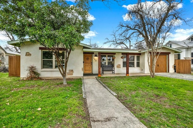 single story home with a garage, a front yard, and a porch