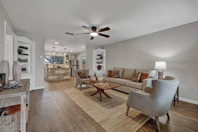 living room featuring wood-type flooring and ceiling fan