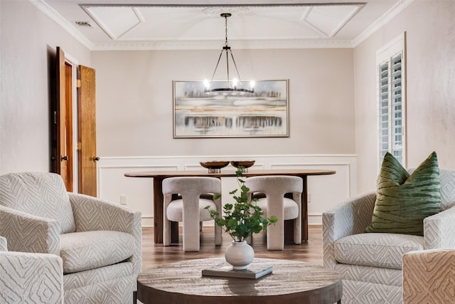 sitting room with crown molding, a chandelier, and hardwood / wood-style flooring