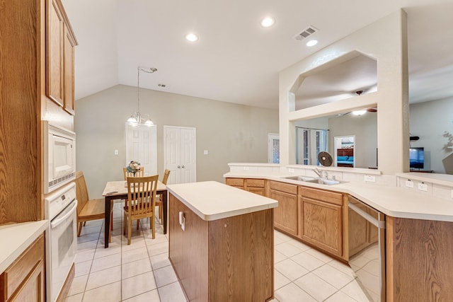 kitchen with white appliances, a center island, sink, and kitchen peninsula