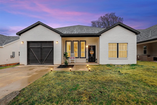 view of front of home with a yard and a garage