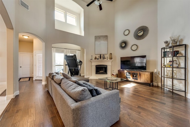 living room with ceiling fan, plenty of natural light, and dark hardwood / wood-style floors