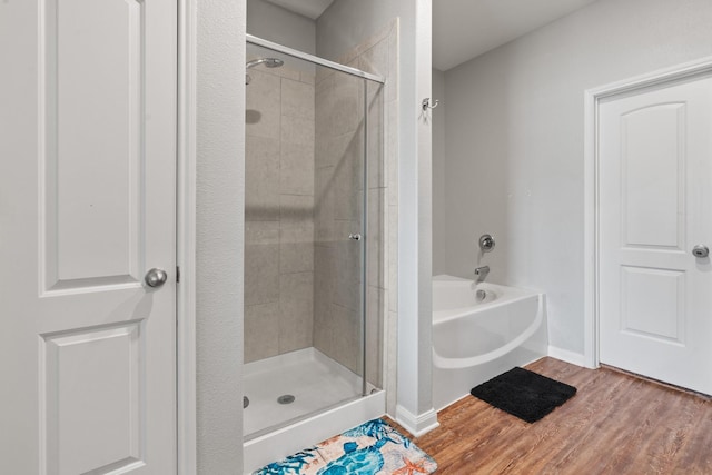 bathroom with hardwood / wood-style flooring and separate shower and tub