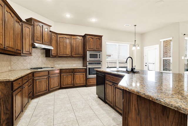 kitchen featuring light tile patterned flooring, under cabinet range hood, stainless steel appliances, a sink, and backsplash