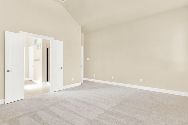 unfurnished bedroom featuring light carpet, high vaulted ceiling, and baseboards