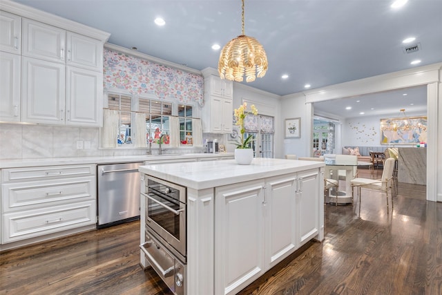 kitchen with white cabinetry, decorative light fixtures, dark hardwood / wood-style floors, a kitchen island, and stainless steel appliances