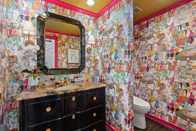 bathroom with crown molding, vanity, toilet, and hardwood / wood-style floors