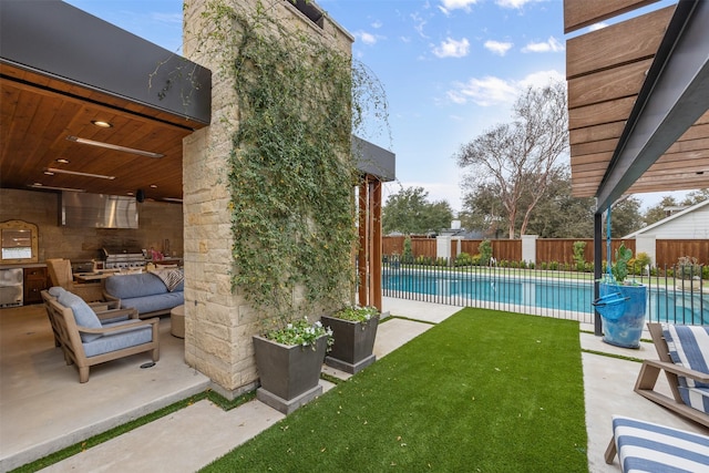 view of yard featuring a fenced in pool, an outdoor living space, a patio, and exterior kitchen