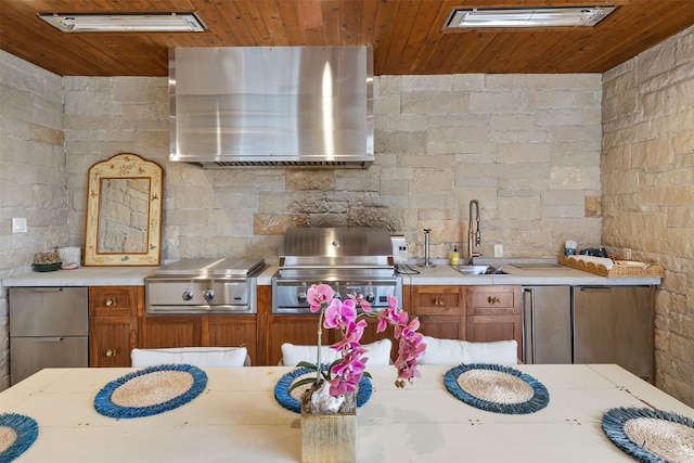 kitchen featuring stainless steel refrigerator, sink, fridge, wall chimney range hood, and wooden ceiling