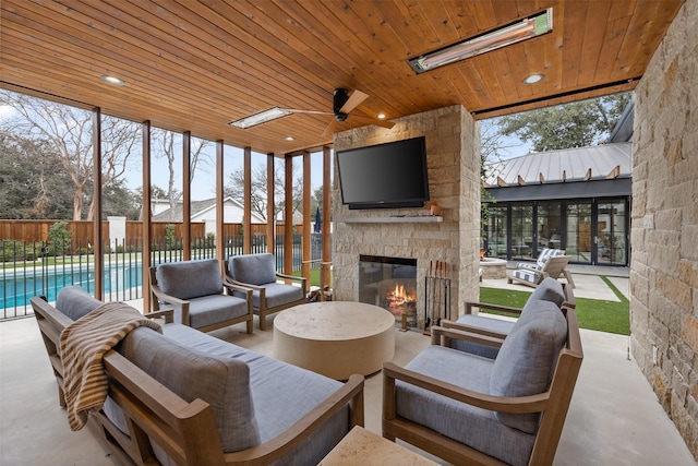 view of patio / terrace with ceiling fan, an outdoor living space with a fireplace, and a fenced in pool