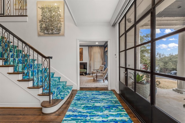 foyer entrance with crown molding and dark hardwood / wood-style floors