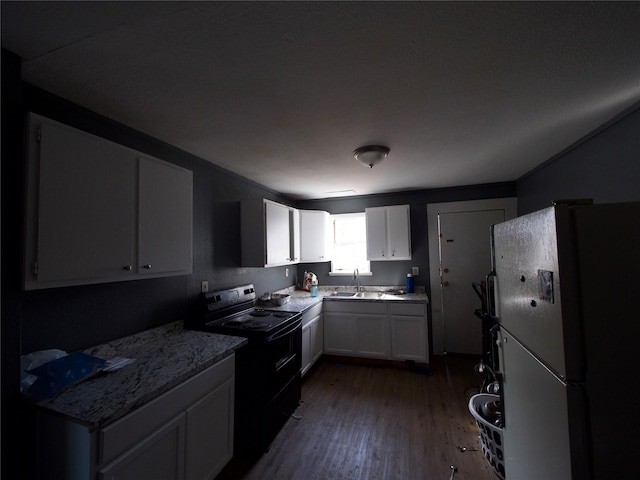 kitchen with sink, white refrigerator, dark hardwood / wood-style flooring, black range with electric cooktop, and white cabinets