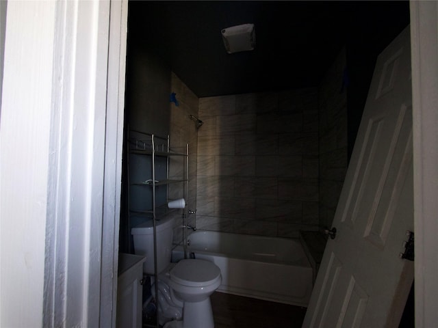 full bathroom featuring vanity, tiled shower / bath, and toilet