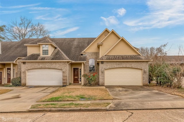 view of front facade with a garage, driveway, and brick siding