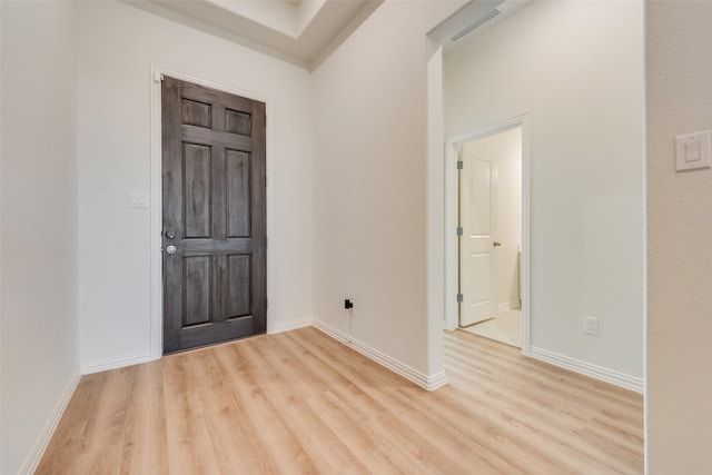 foyer entrance featuring light wood-style flooring and baseboards