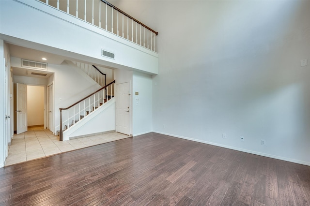 interior space with light hardwood / wood-style floors and a high ceiling