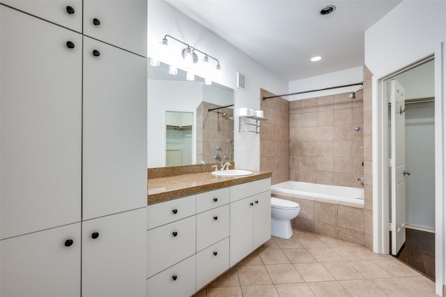 full bathroom with vanity, tiled shower / bath combo, tile patterned floors, and toilet