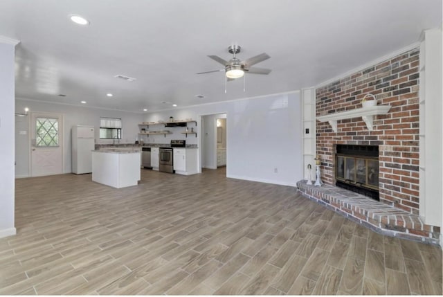 unfurnished living room with light hardwood / wood-style flooring, a fireplace, and ceiling fan