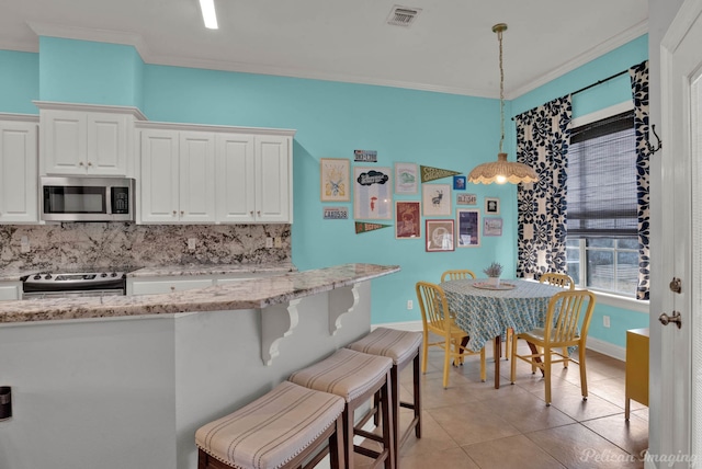 kitchen with white cabinetry, decorative light fixtures, ornamental molding, and appliances with stainless steel finishes