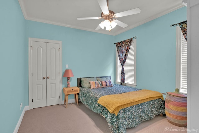 carpeted bedroom with crown molding, ceiling fan, and a closet