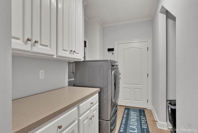 washroom featuring washer / clothes dryer, ornamental molding, and cabinets