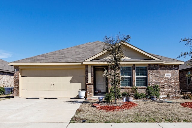 ranch-style home featuring concrete driveway, a garage, central AC unit, and brick siding