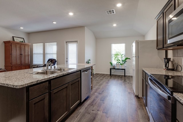 kitchen with visible vents, dark brown cabinets, dark wood-type flooring, stainless steel appliances, and a sink